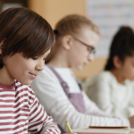 Kidds sitting in the classroom working.