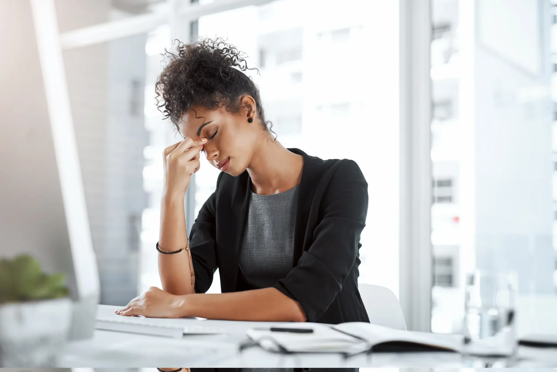 woman with hand on face taking a break from using the computer